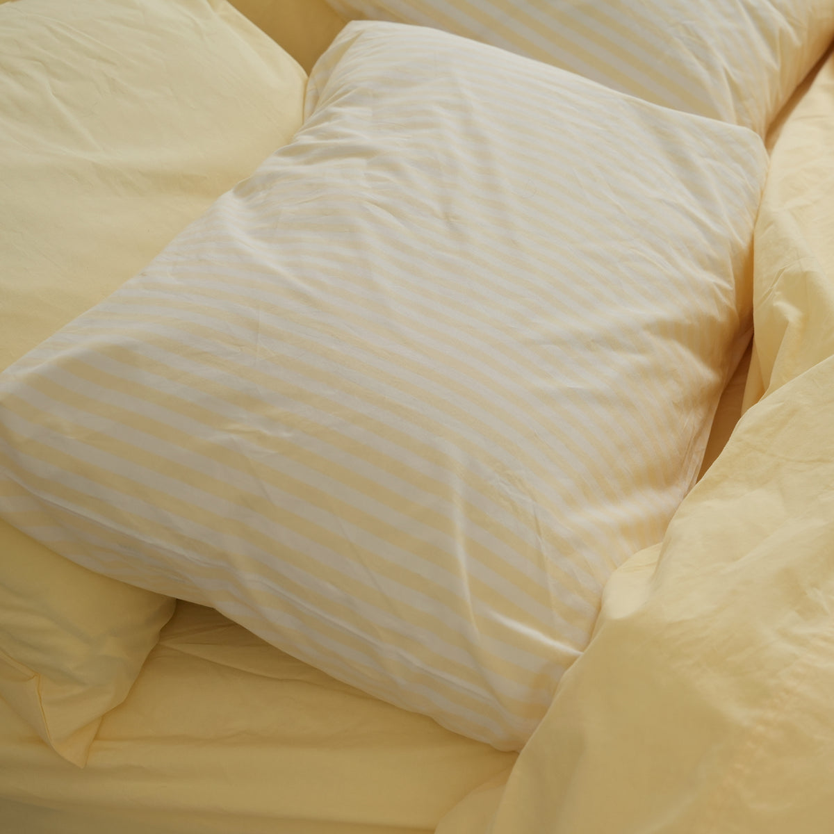 100% stonewashed cotton pillowcase pair in butter stripe, close-up