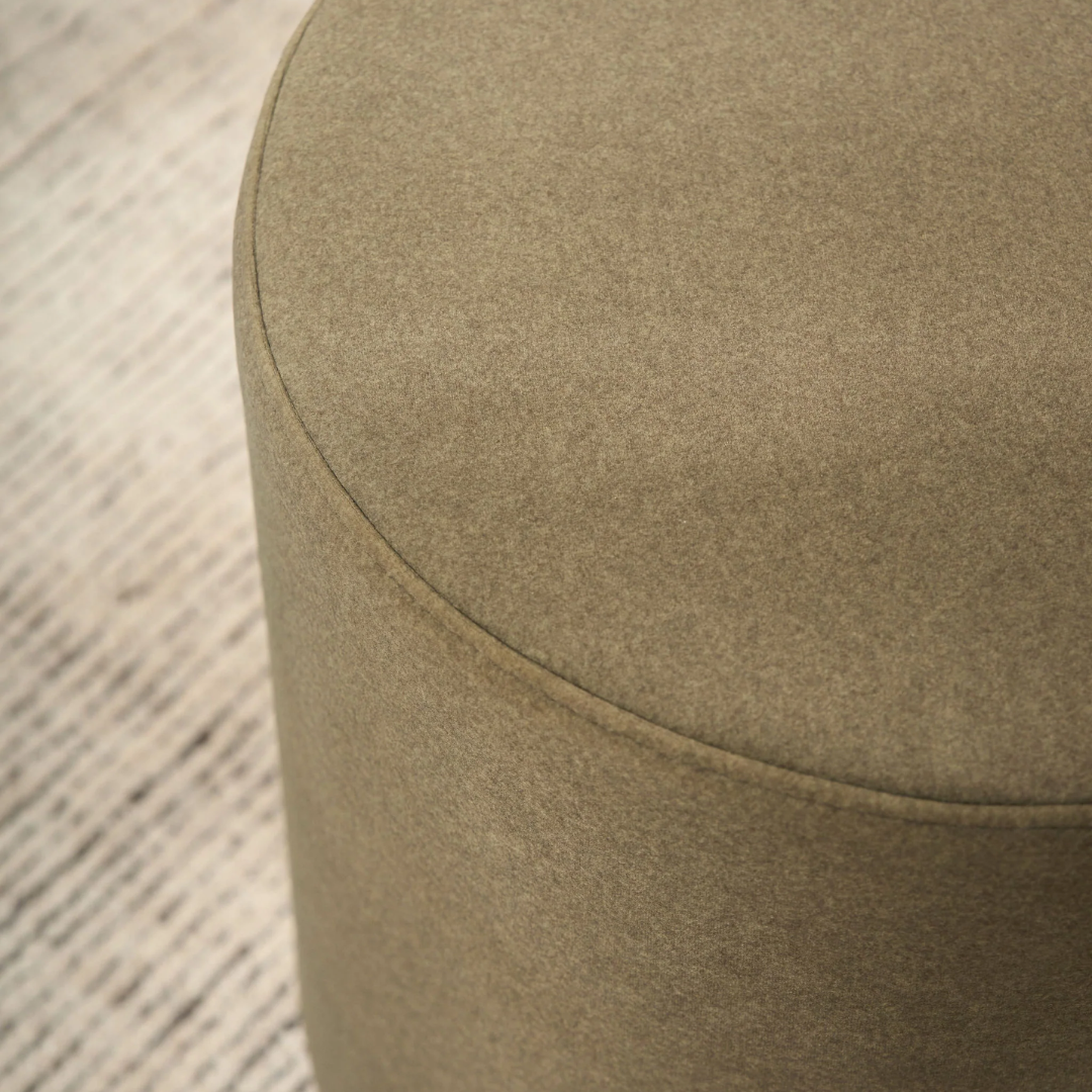 Mee swivel ottoman in Olive, compact form, smooth swivel base, styled view
