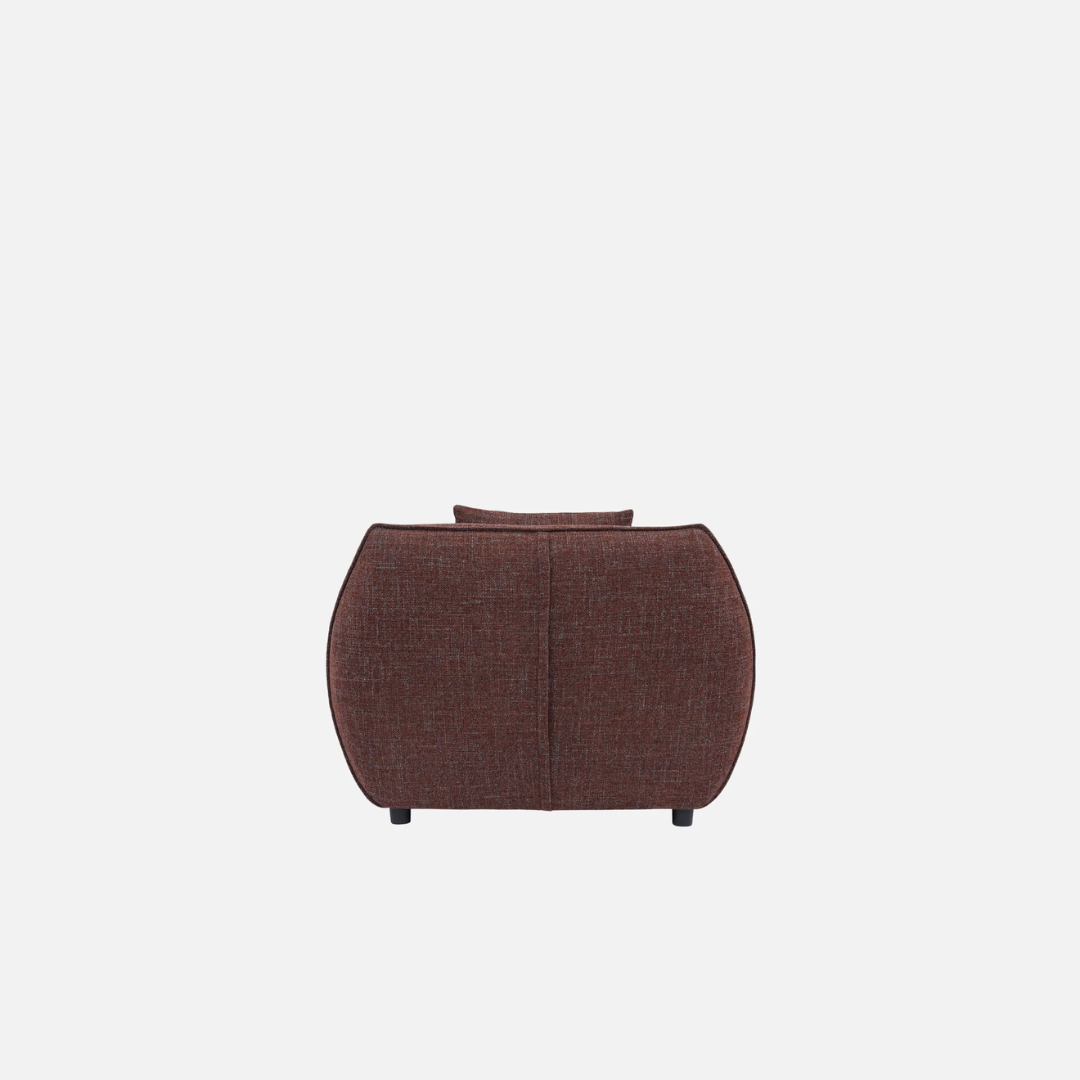 Nearly Famous armchair, rounded silhouette, plush upholstery, close-up